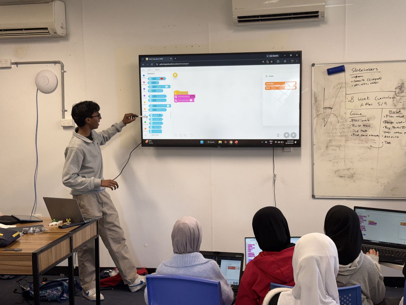 A student teaching code on a screen