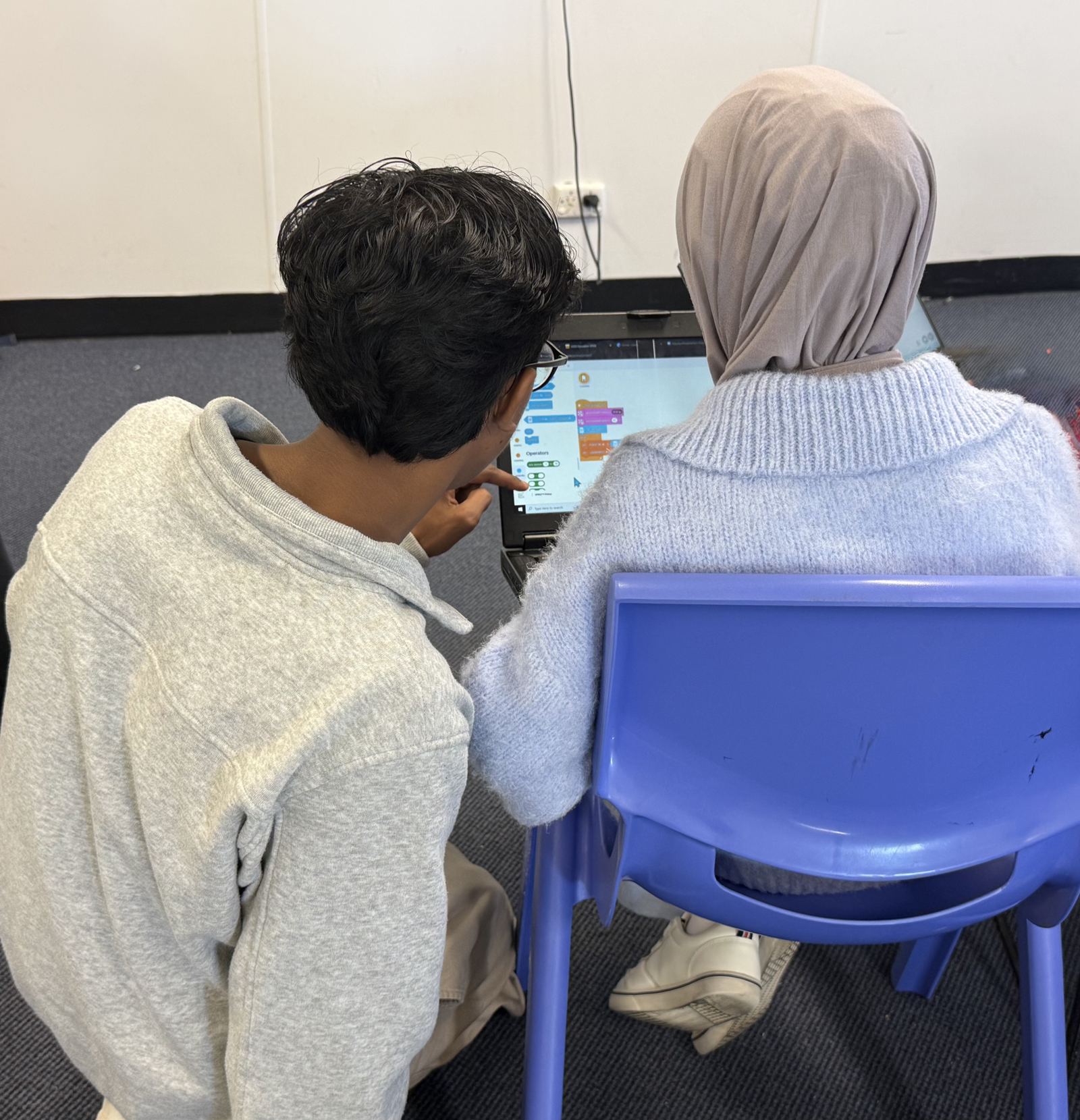 A mentor and a student working through code together